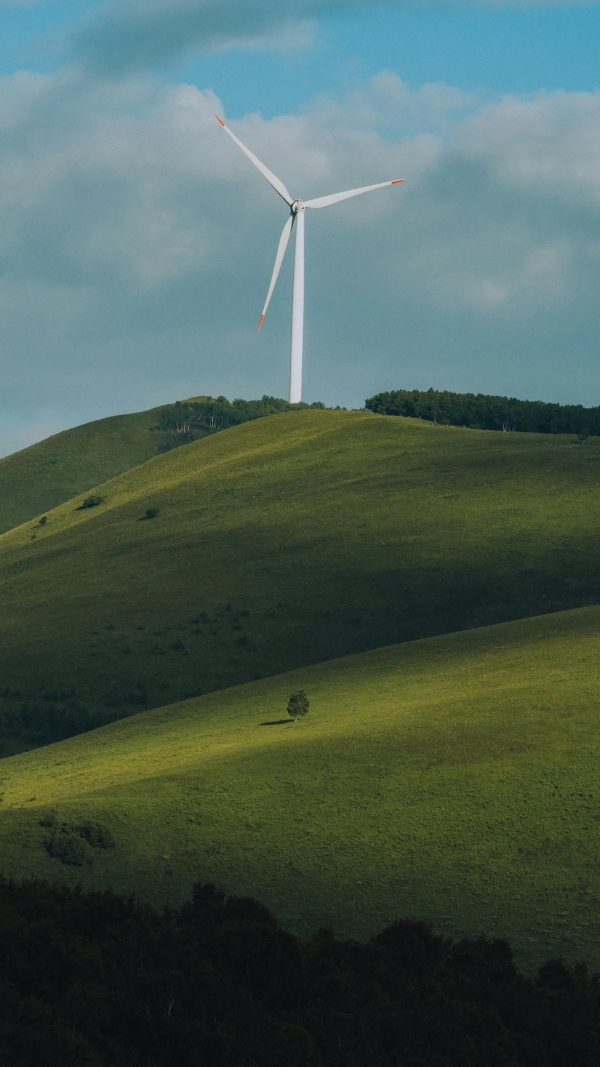 Windkraftanlage auf grünen Hügeln